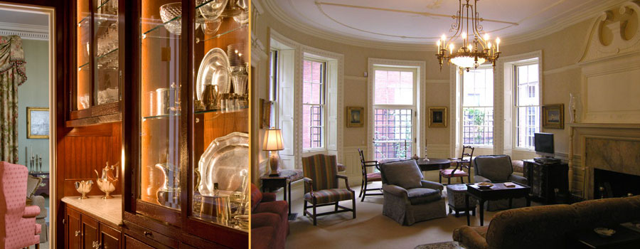 Bow-front Boston parlour lit by a brass chandelier and lamps