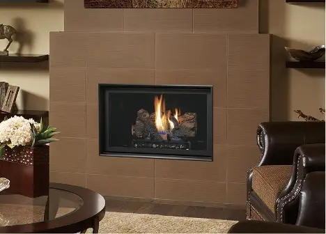 Tiled living room fireplace with a fire lit, an armchair and a coffee table beside it